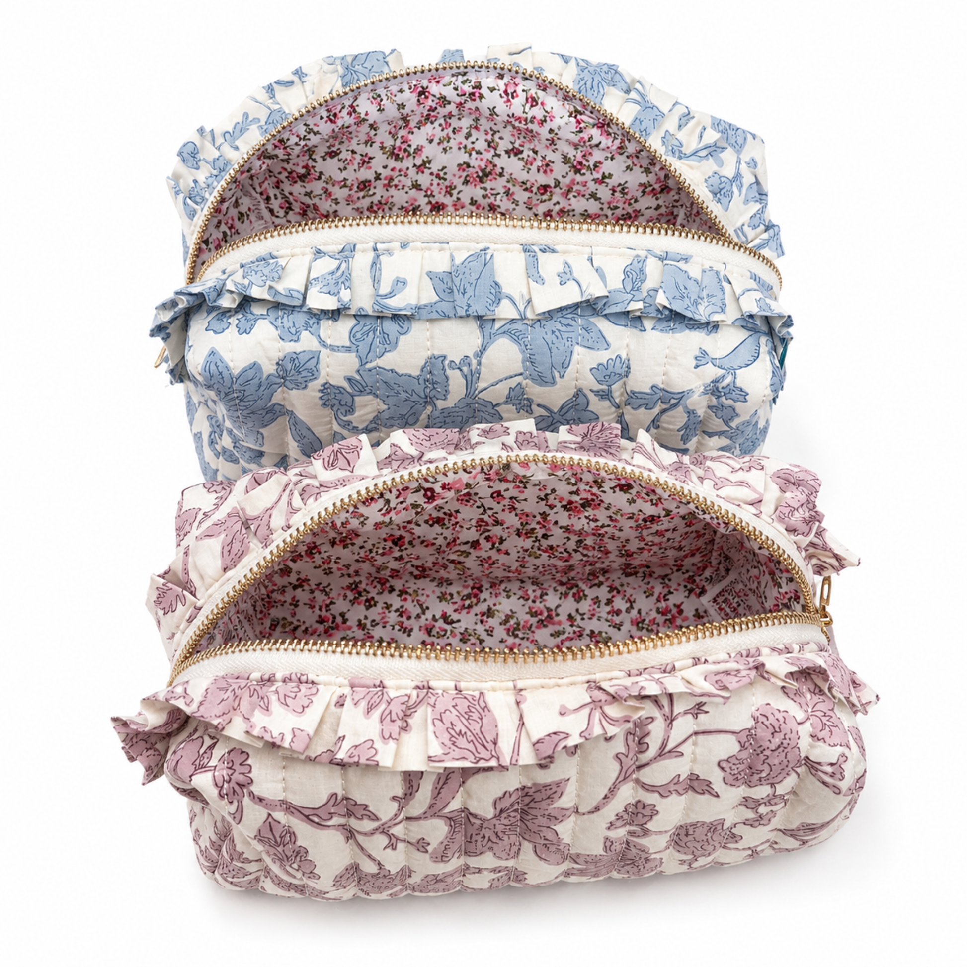 Two ruffled fabric pouches with gold zippers, stacked vertically on a white background. The top pouch is light blue and white floral, and the bottom pouch is dusty pink and white floral, both with matching floral lining.